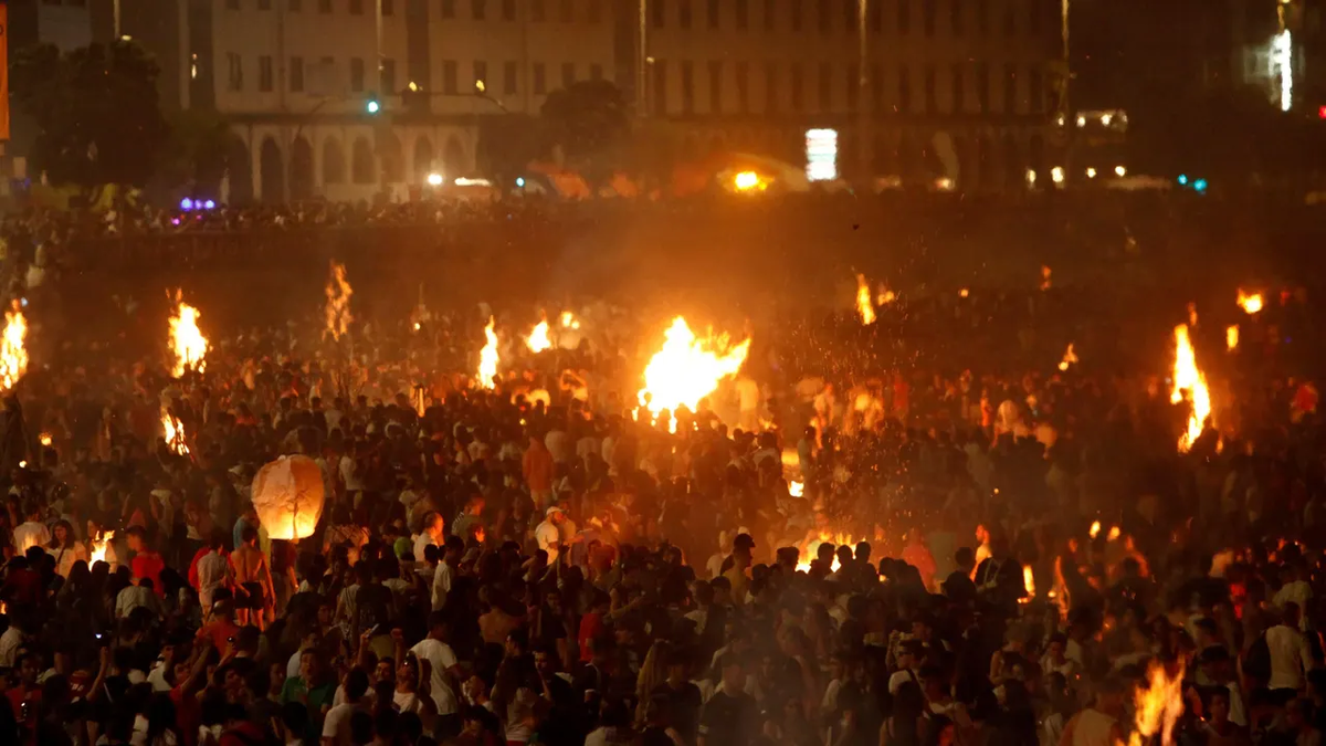 Familias bilbaínas reunidas alrededor de una hoguera en la Noche de San Juan, celebrando una tradición centenaria en Bilbao