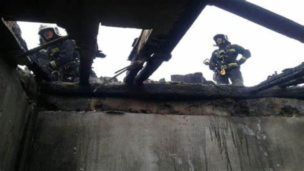 Bomberos en acción en la fachada humeante de un edificio en Sopela durante un incendio.