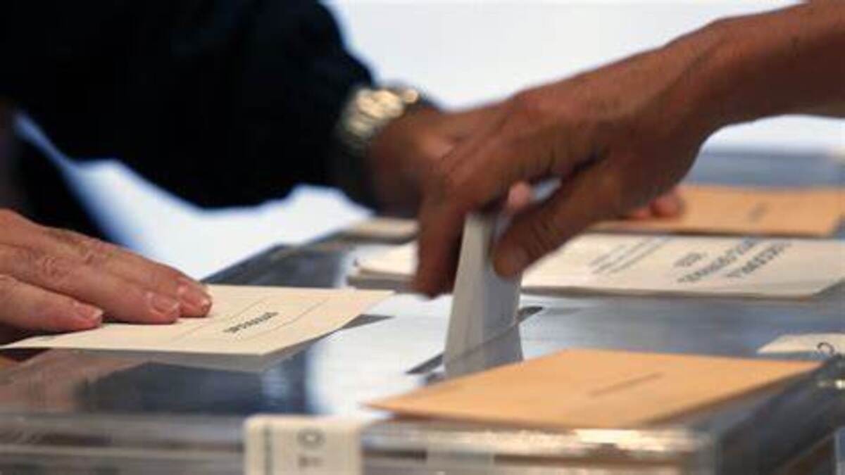 Ciudadano introduciendo su voto en la urna en una mesa electoral de Bilbao.