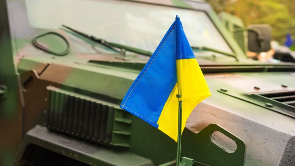 Tanque de guerra con la bandera de Ucrania en un campo de batalla.