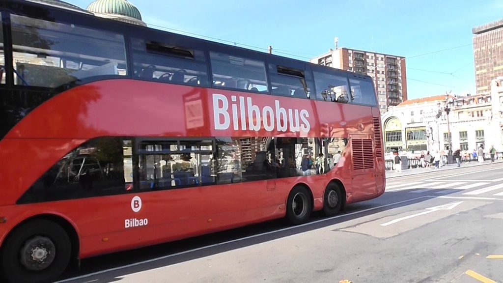 Imagen de una parada de Bilbobus con un autobús esperando a pasajeros en un día soleado.