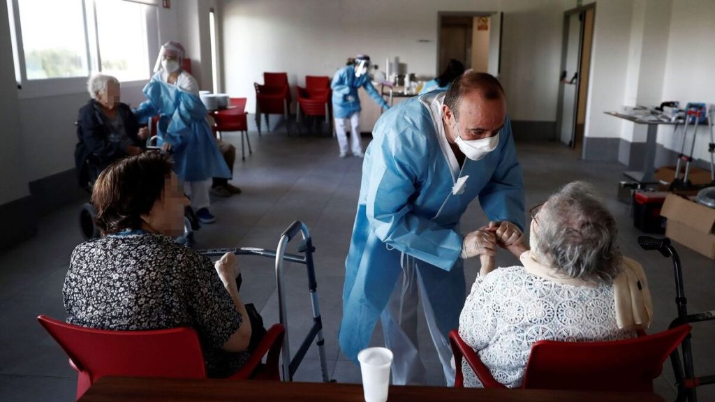 Grupo de médicos y enfermeros en una residencia de Bizkaia atendiendo a dos adultos mayores.