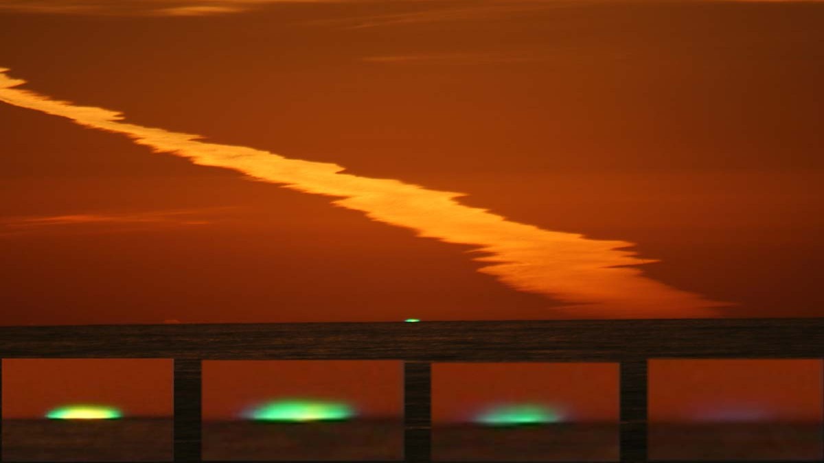 Imagen de la costa mostrando el fenómeno del rayo verde al atardecer.