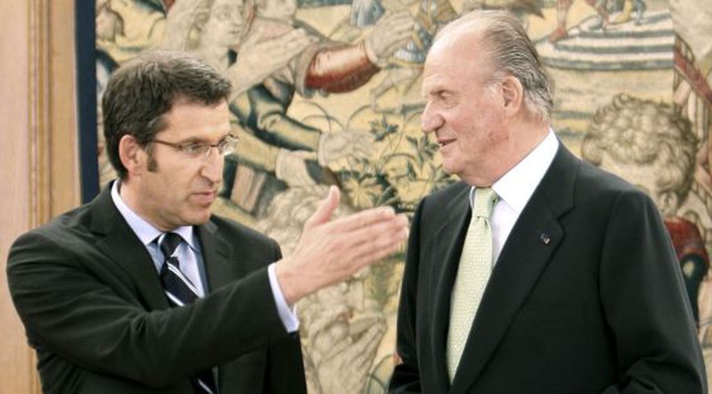 Alberto Núñez Feijóo y el rey Juan Carlos I conversando en un encuentro político.