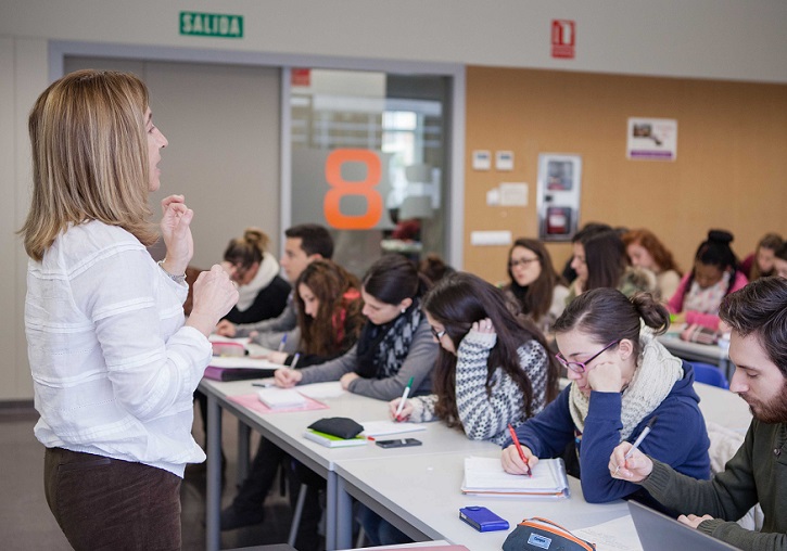 Profesora impartiendo clases en un aula universitaria.