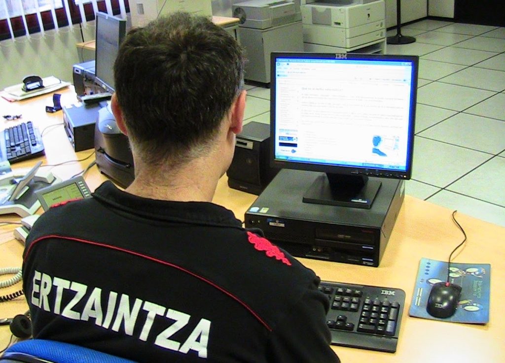 Foto de un miembro de la Ertzaintza en su puesto de trabajo, investigando el caso de estafas en ventas de vehículos en Bizkaia.