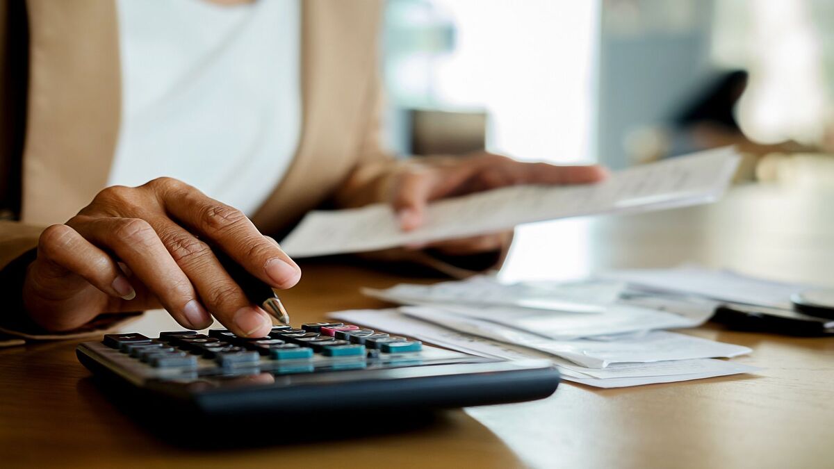 Persona realizando cálculos en una calculadora para estimar su pensión de jubilación.