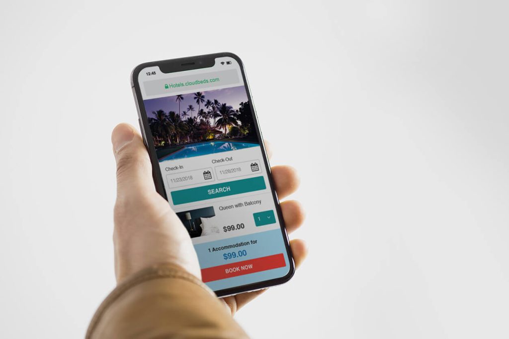 Persona reservando en una plataforma de alojamiento con su teléfono móvil.