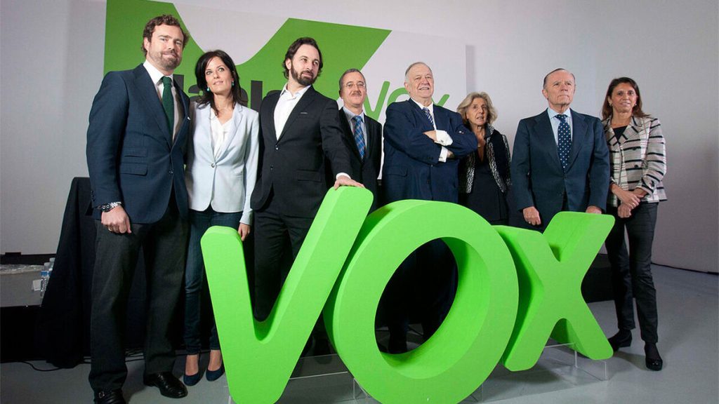 Dirigentes de Vox junto al logotipo del partido.