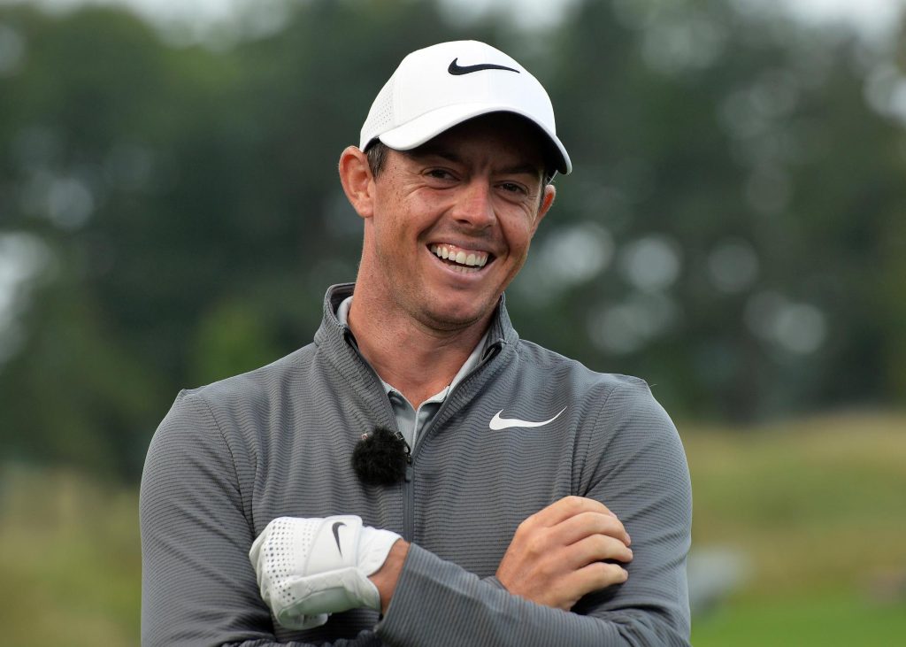 Rory McIlroy sonriendo en el campo de golf