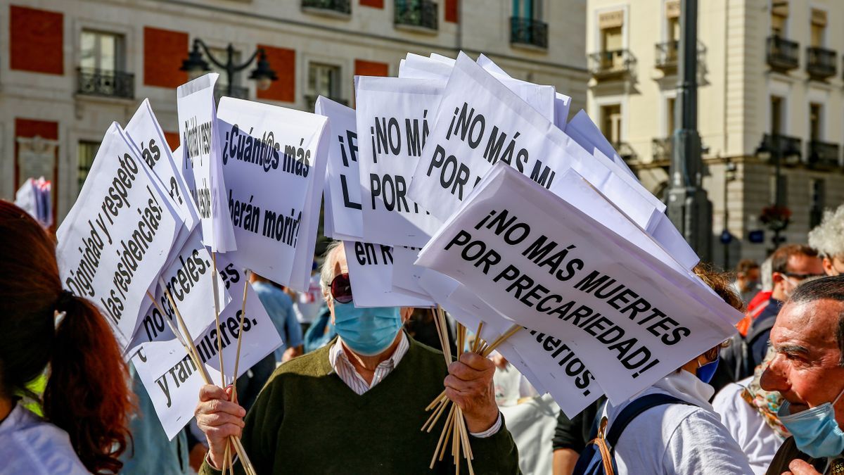 Miembros de Marea de Residencias portan carteles en un acto público en Madrid.